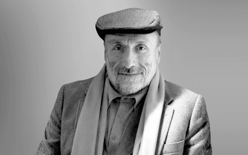 Man smiling at the camera against a gray background