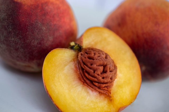 Whole peaches with a halved peach in front