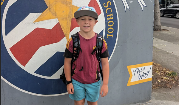 Boy standing in front of his school