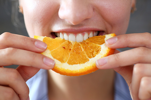 Woman eating orange slice