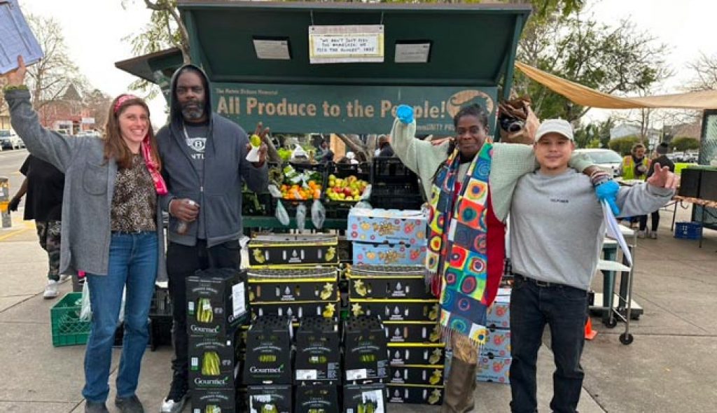 People standing in front of donated boxes of fresh produce.